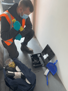 Pest control engineer inspecting a rodent bait station